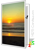 Golden sunset over beach with sun reflecting on wet sand and gentle shore waves